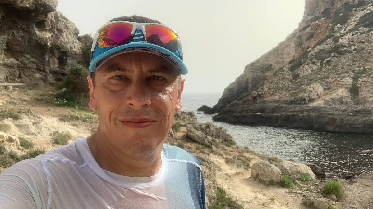 Selfie con cappellino e occhiali da sole su una scogliera sul mare