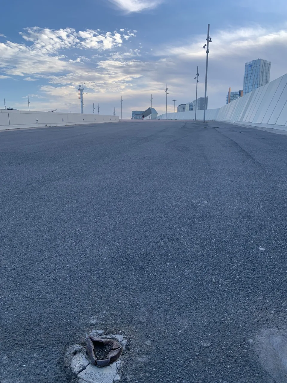 Strada asfaltata deserta lungo il mare con un edificio sullo sfondo
