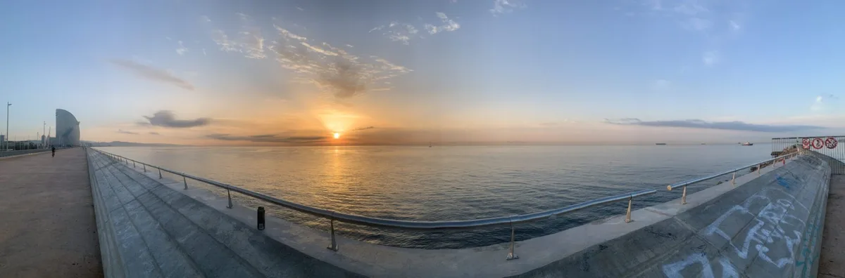 Panorama del molo e del mare all'alba con l'Hotel Vela