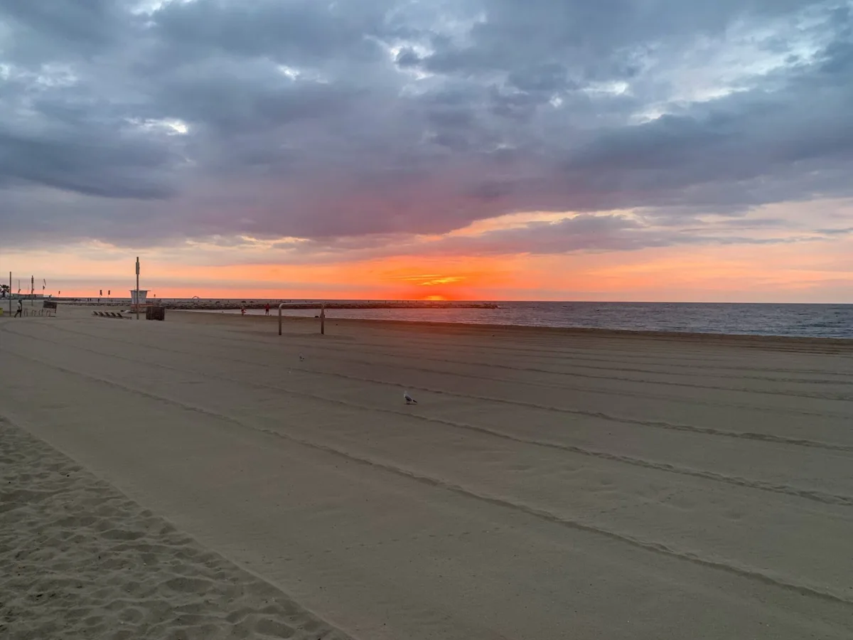 Cielo rosso all'alba sopra la spiaggia deserta