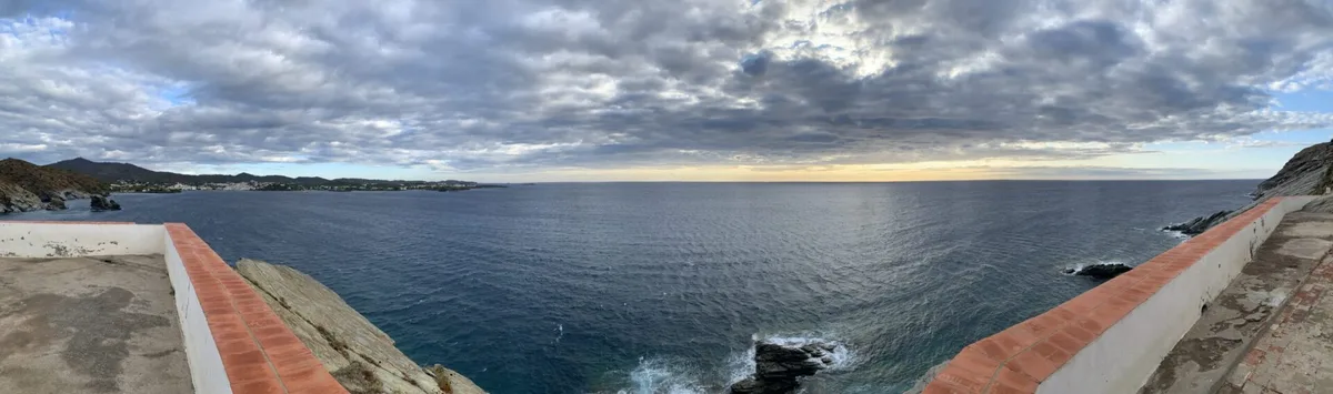 Panorama del mare dalle rocce con un muretto rosso