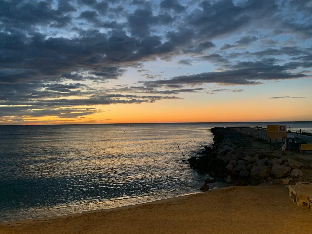 Spiaggia al tramonto sotto nuvole scure