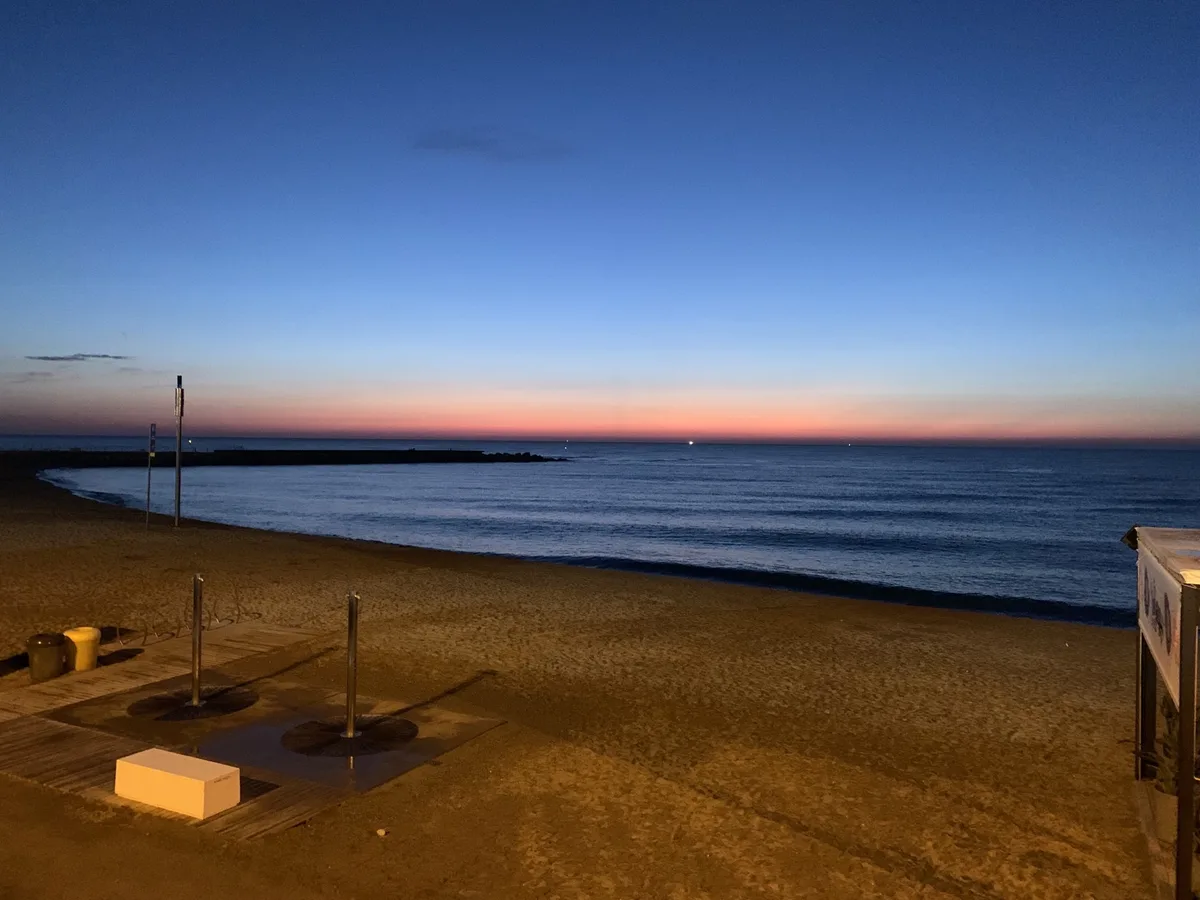 Spiaggia al crepuscolo con il cielo rosa sul mare