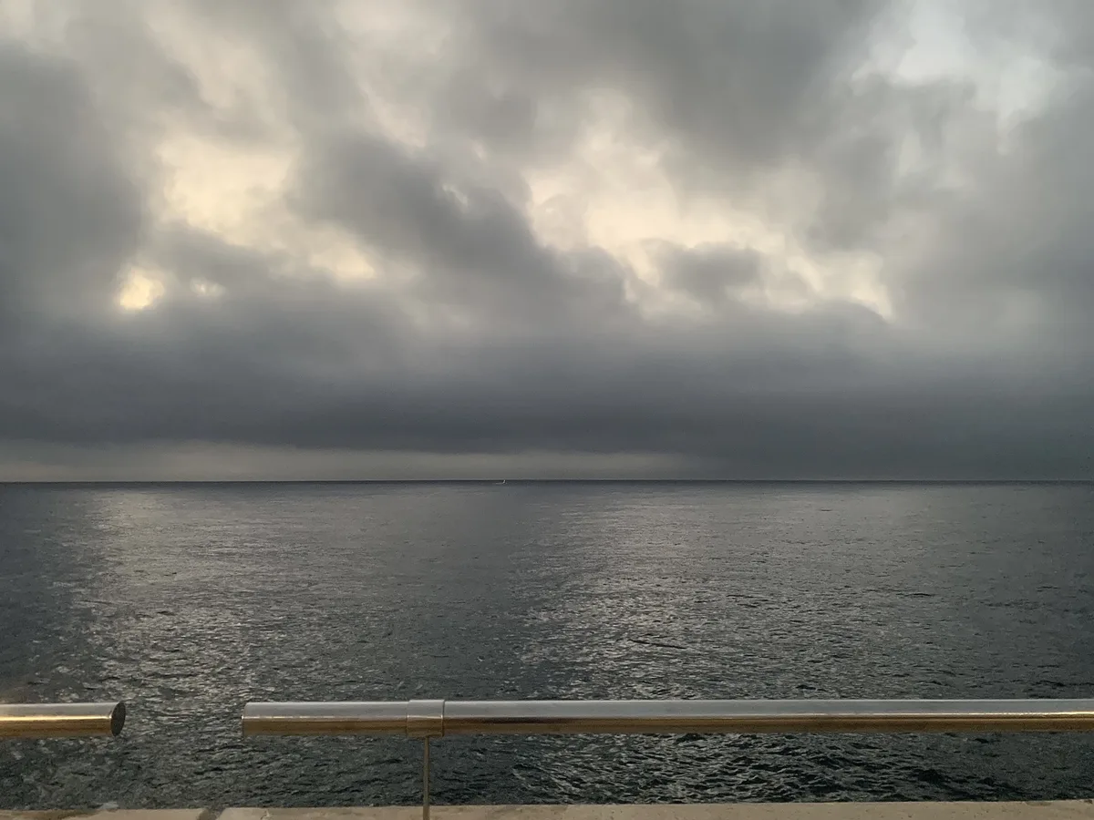 Mare calmo sotto un cielo scuro e nuvoloso