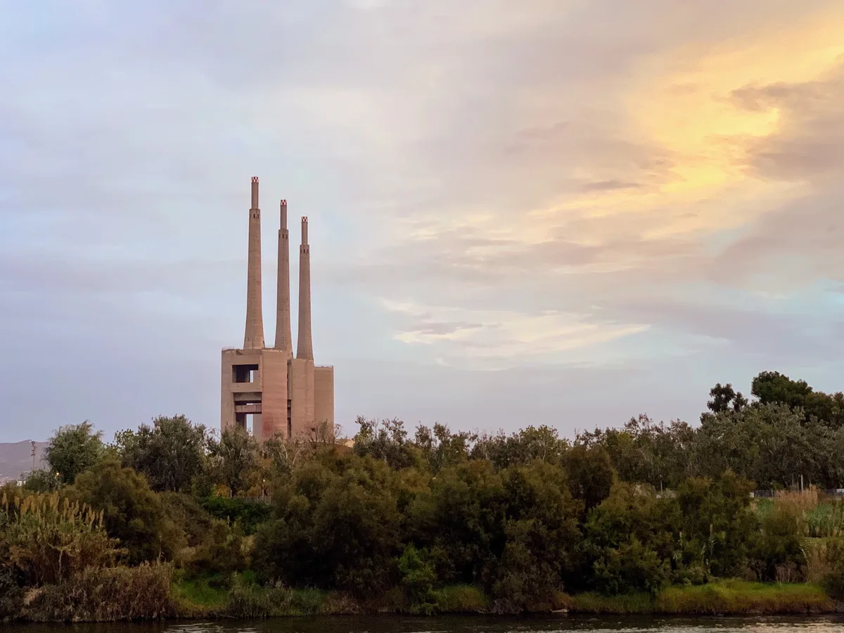 Le tre ciminiere di Sant Adrià de Besòs tra gli alberi al tramonto