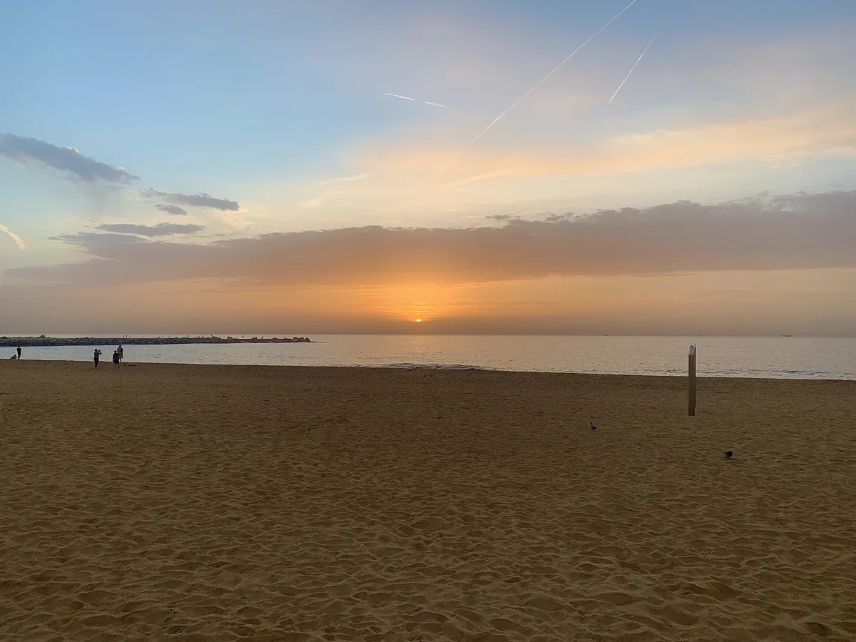 Alba arancione sulla spiaggia con il mare calmo