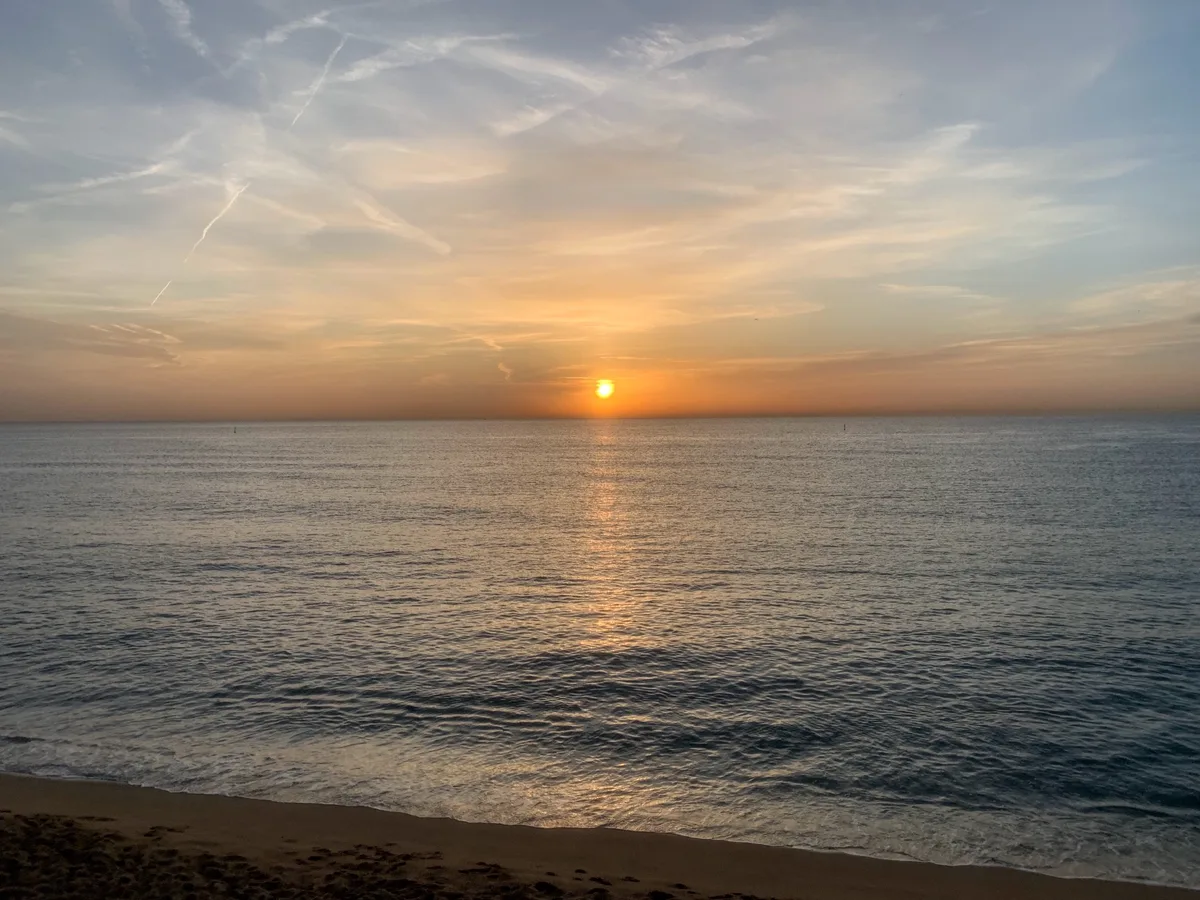 Sole arancione che sorge sul mare