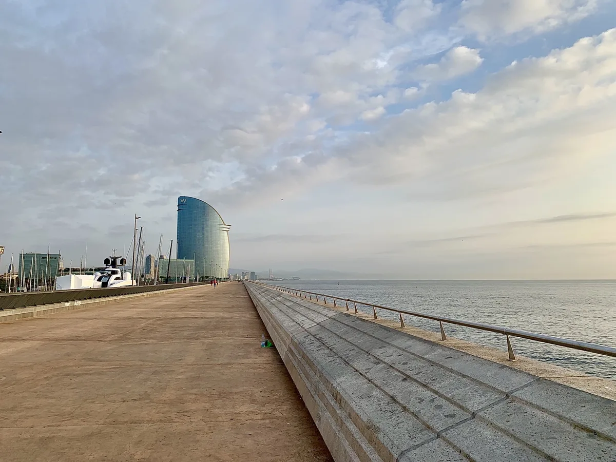Molo con l'Hotel Vela di Barcellona sotto un cielo con nuvole sottili