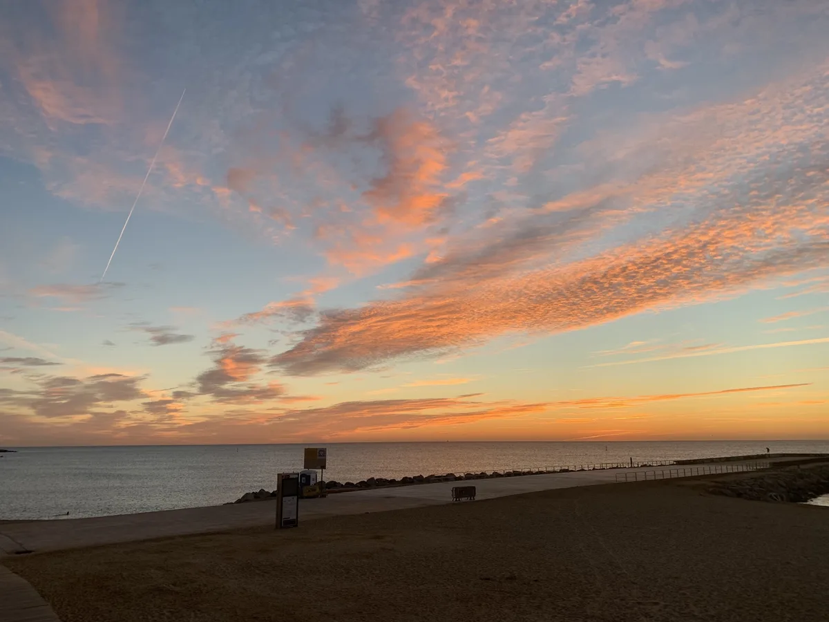 Cielo arancione all'alba sul mare di Barcellona