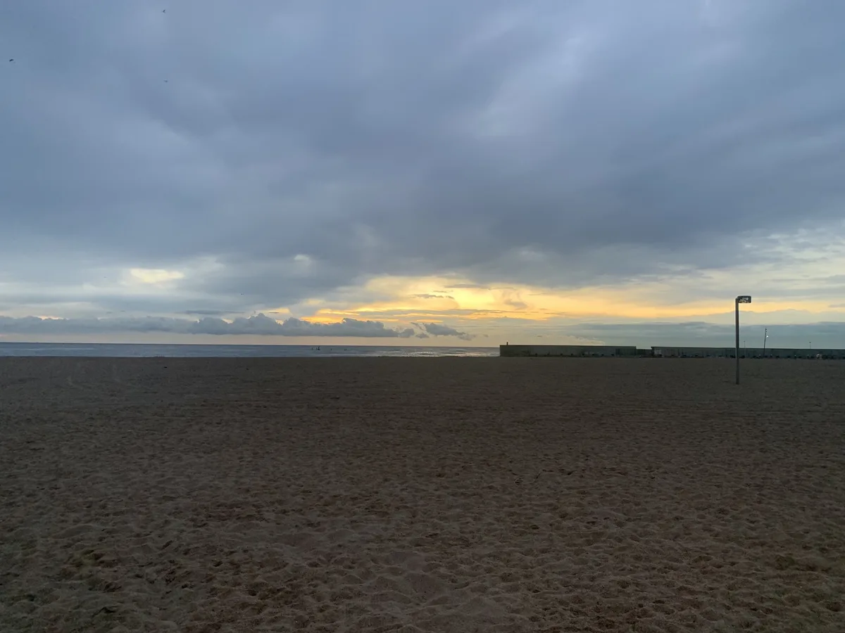 Spiaggia deserta con il cielo nuvoloso all'alba
