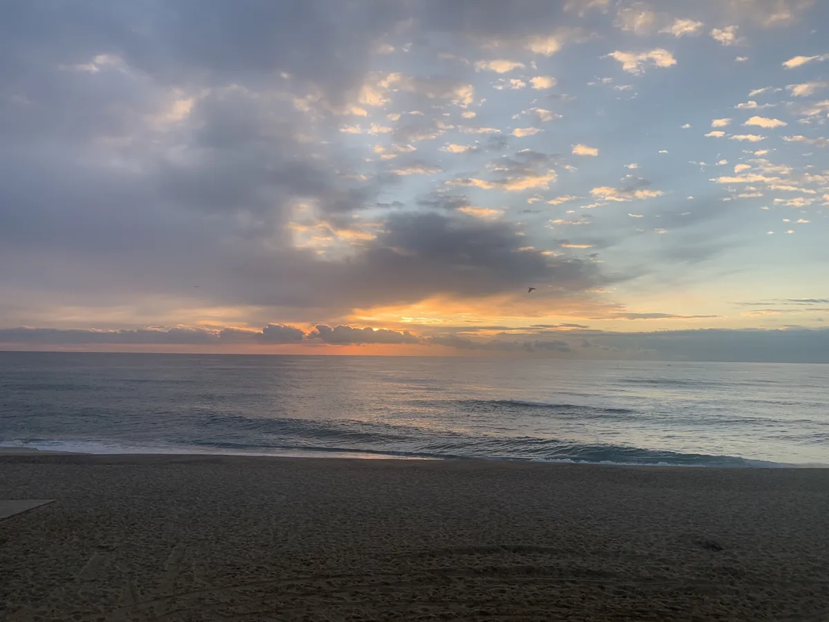 Alba tra le nuvole sul mare dalla spiaggia