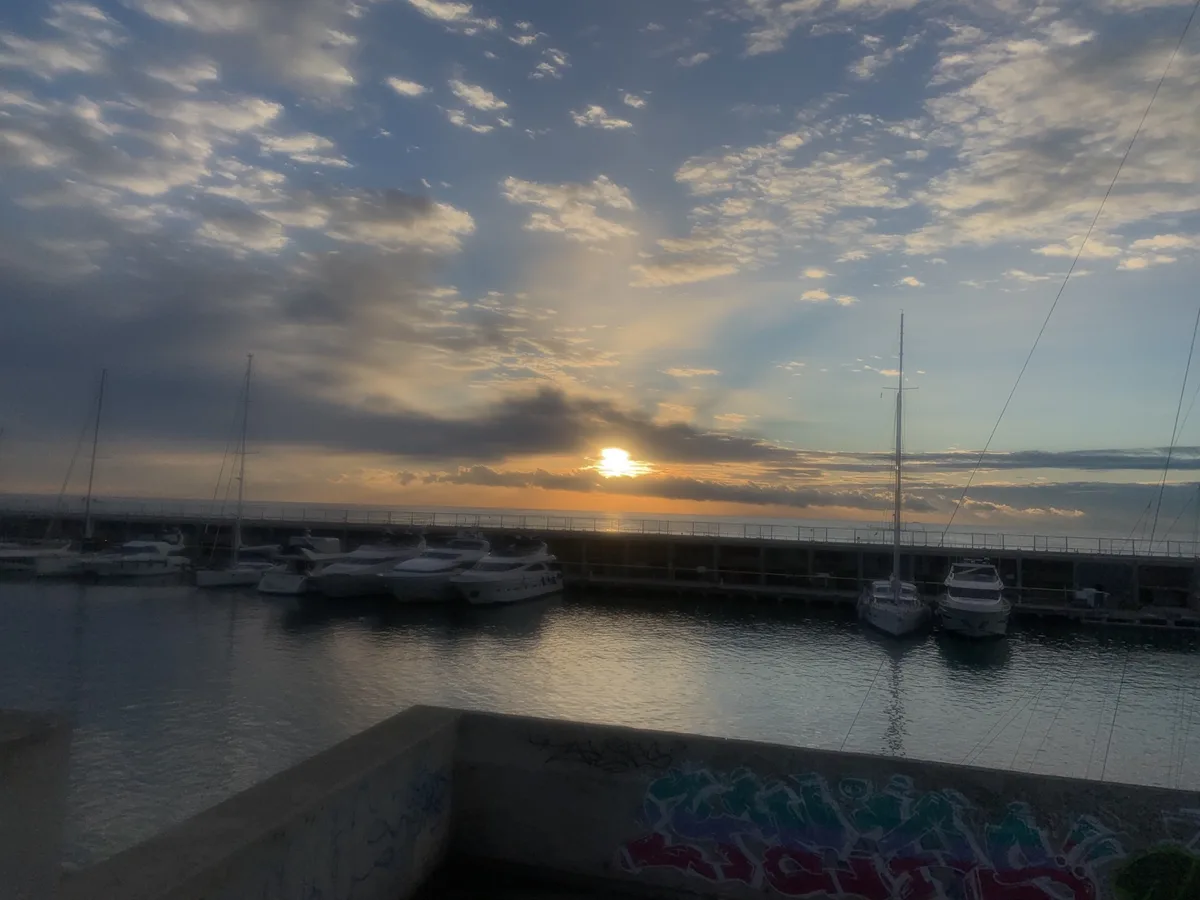 Sole al tramonto sul porticciolo con le barche a vela
