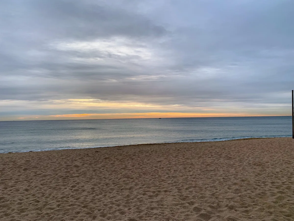 Spiaggia con il cielo grigio e il mare calmo