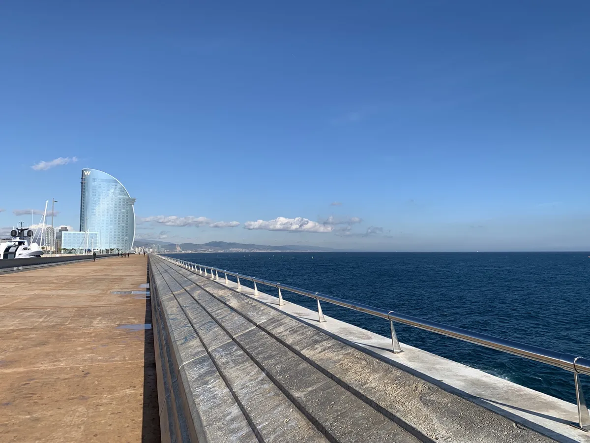 Molo lungo il mare con l'Hotel Vela di Barcellona sullo sfondo