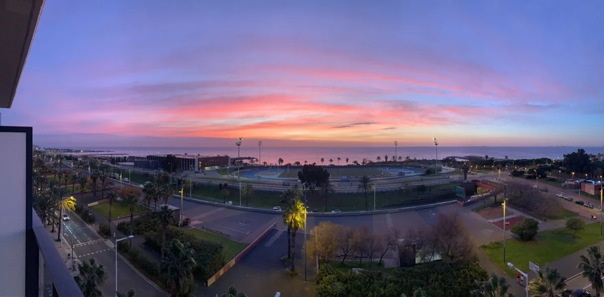 Tramonto rosa e arancione visto dal balcone sul parco e sul mare