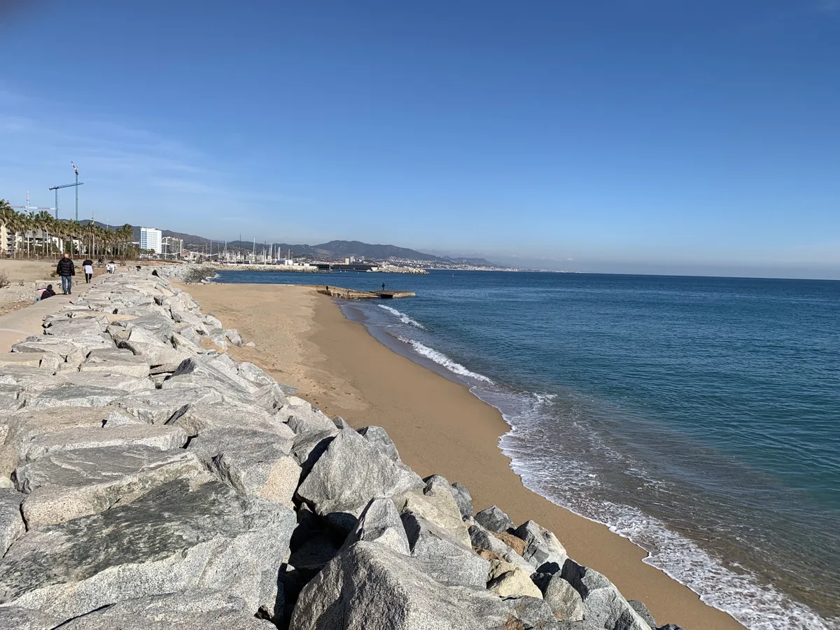 Spiaggia con scogliera di massi e il mare azzurro