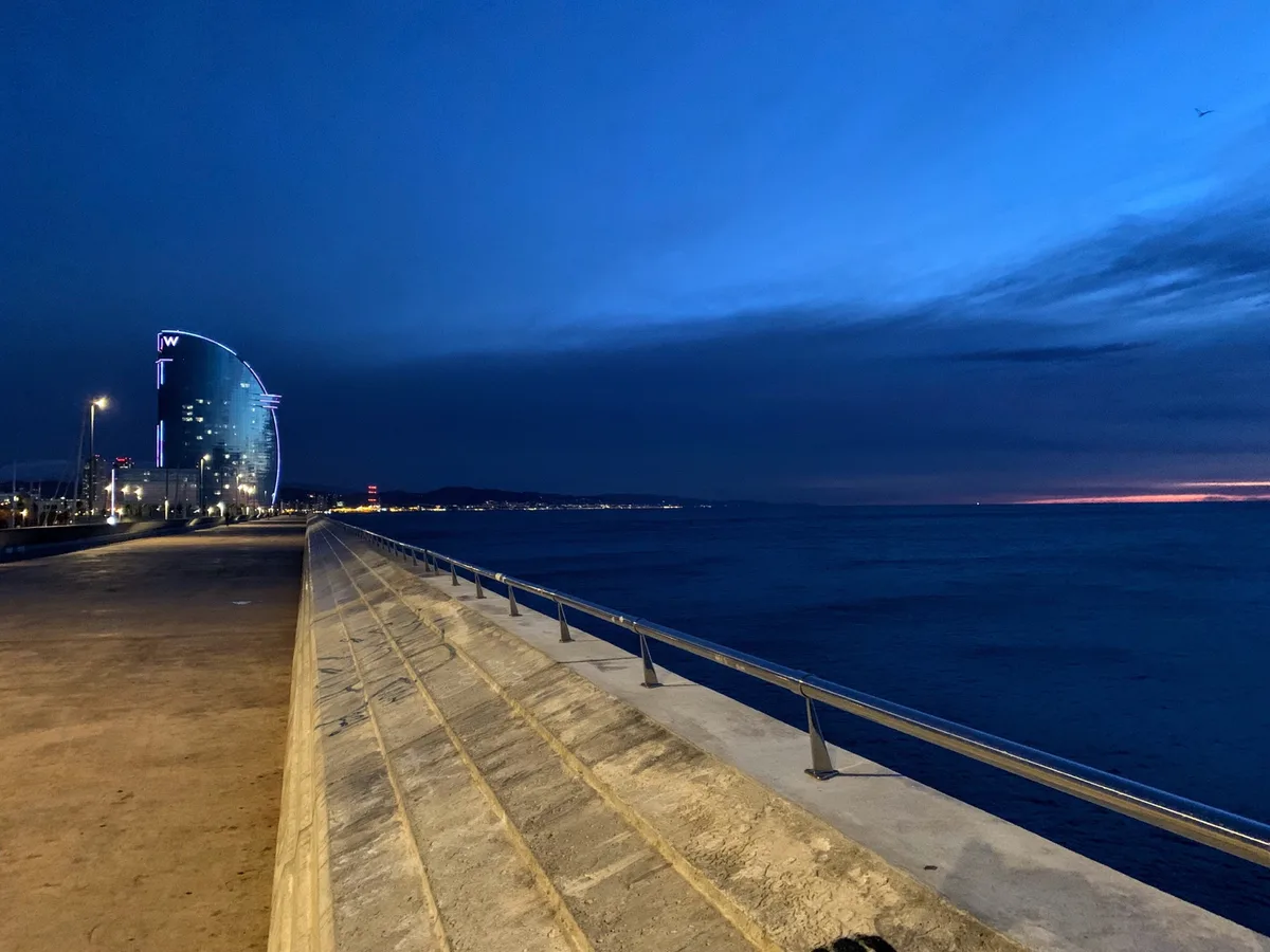 Molo con l'Hotel Vela di Barcellona al crepuscolo