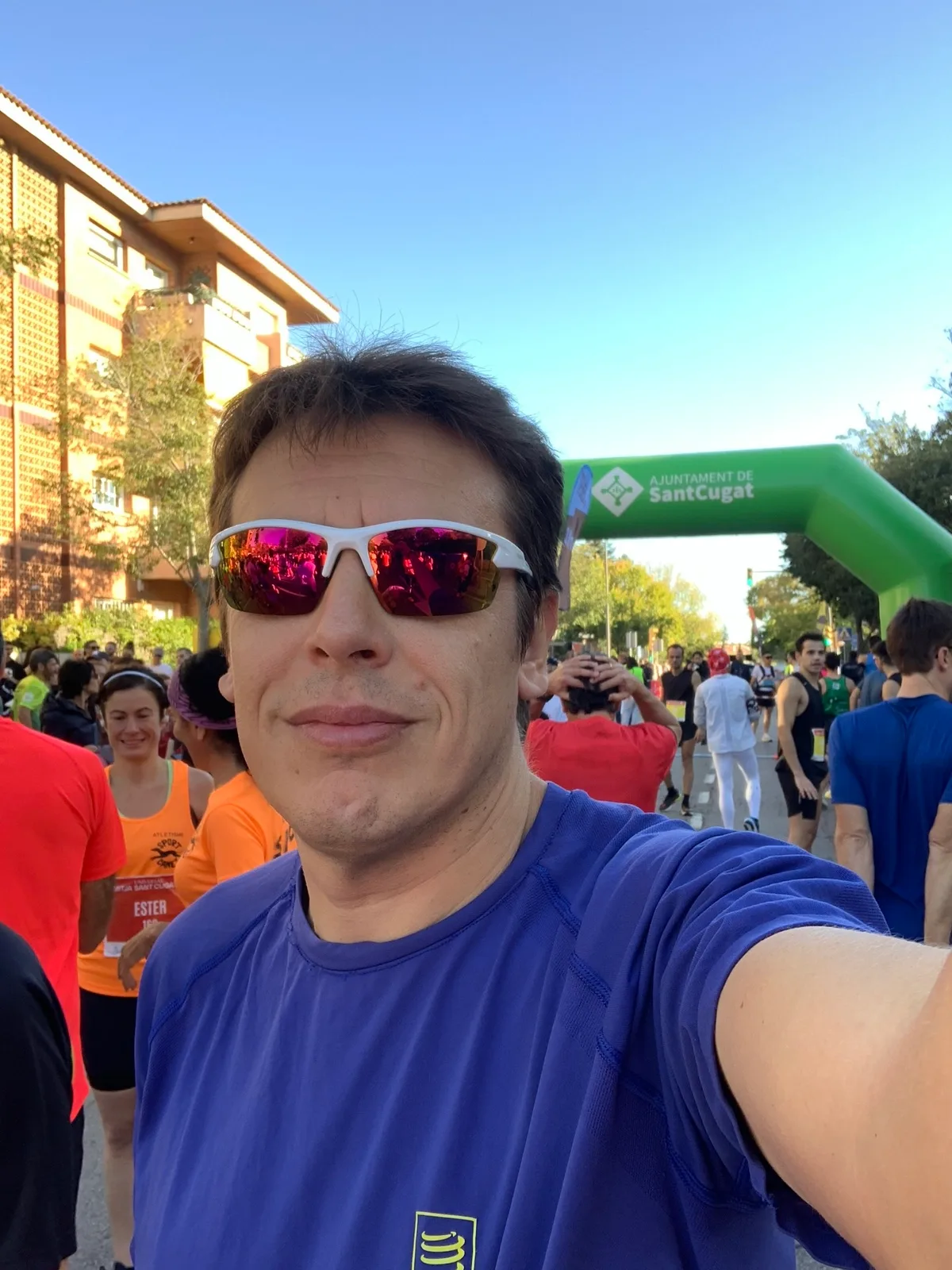 Selfie in maglia blu con occhiali a specchio alla partenza della gara