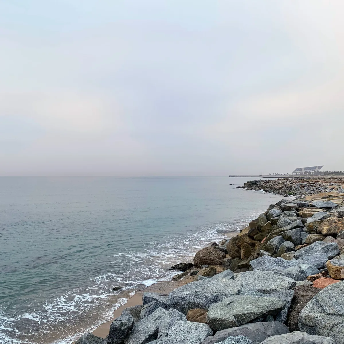 Costa con scogliera frangiflutti e mare calmo