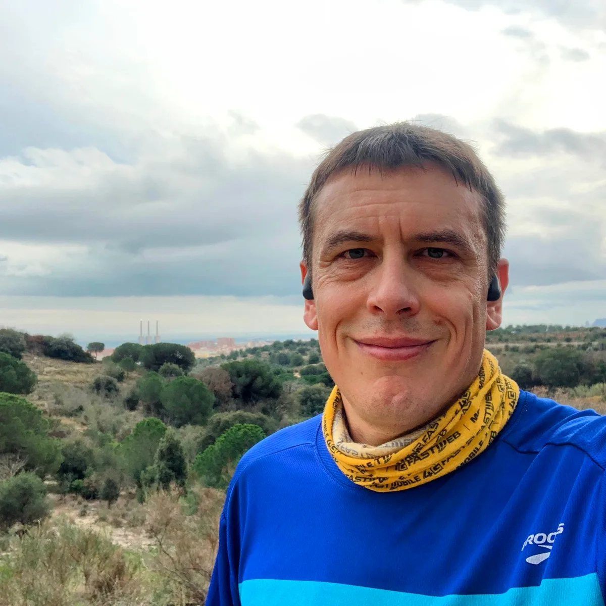 Selfie con scaldacollo giallo su un sentiero di collina