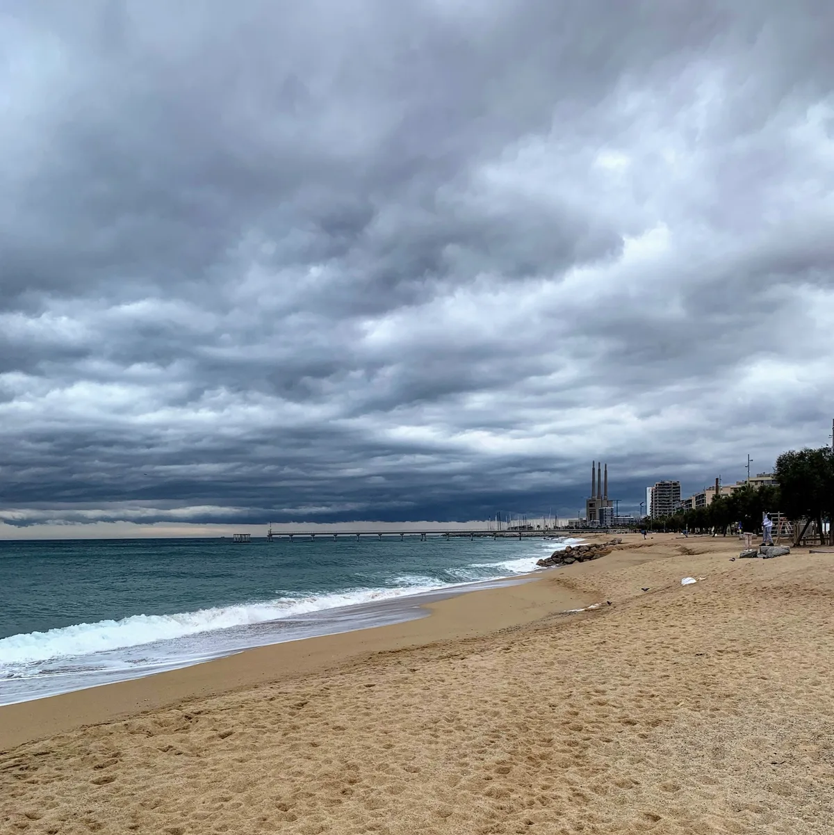 Spiaggia con onde sotto un cielo carico di nuvole
