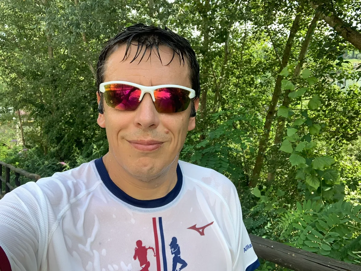 Selfie con occhiali da sole a specchio e maglia bianca di Mizuno nel bosco