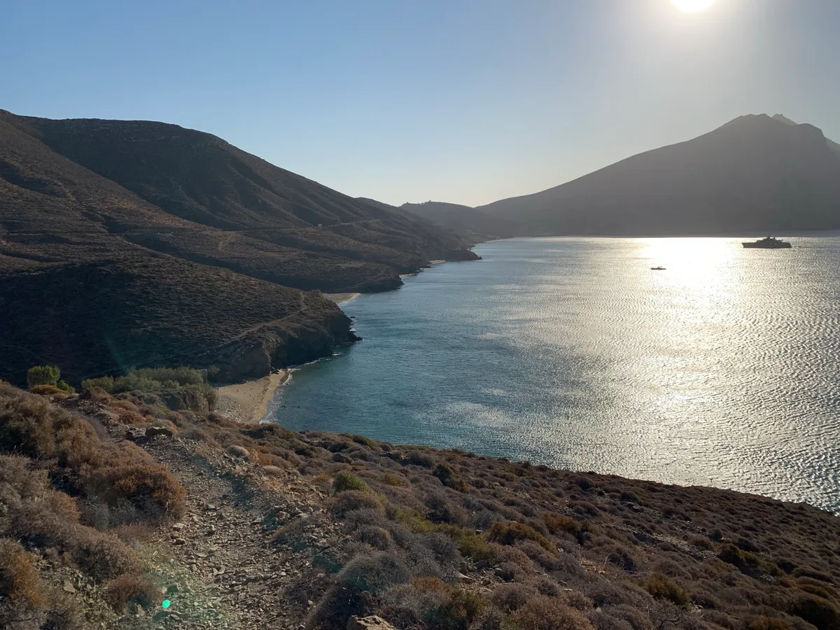 Baia con acqua scintillante tra le colline aride