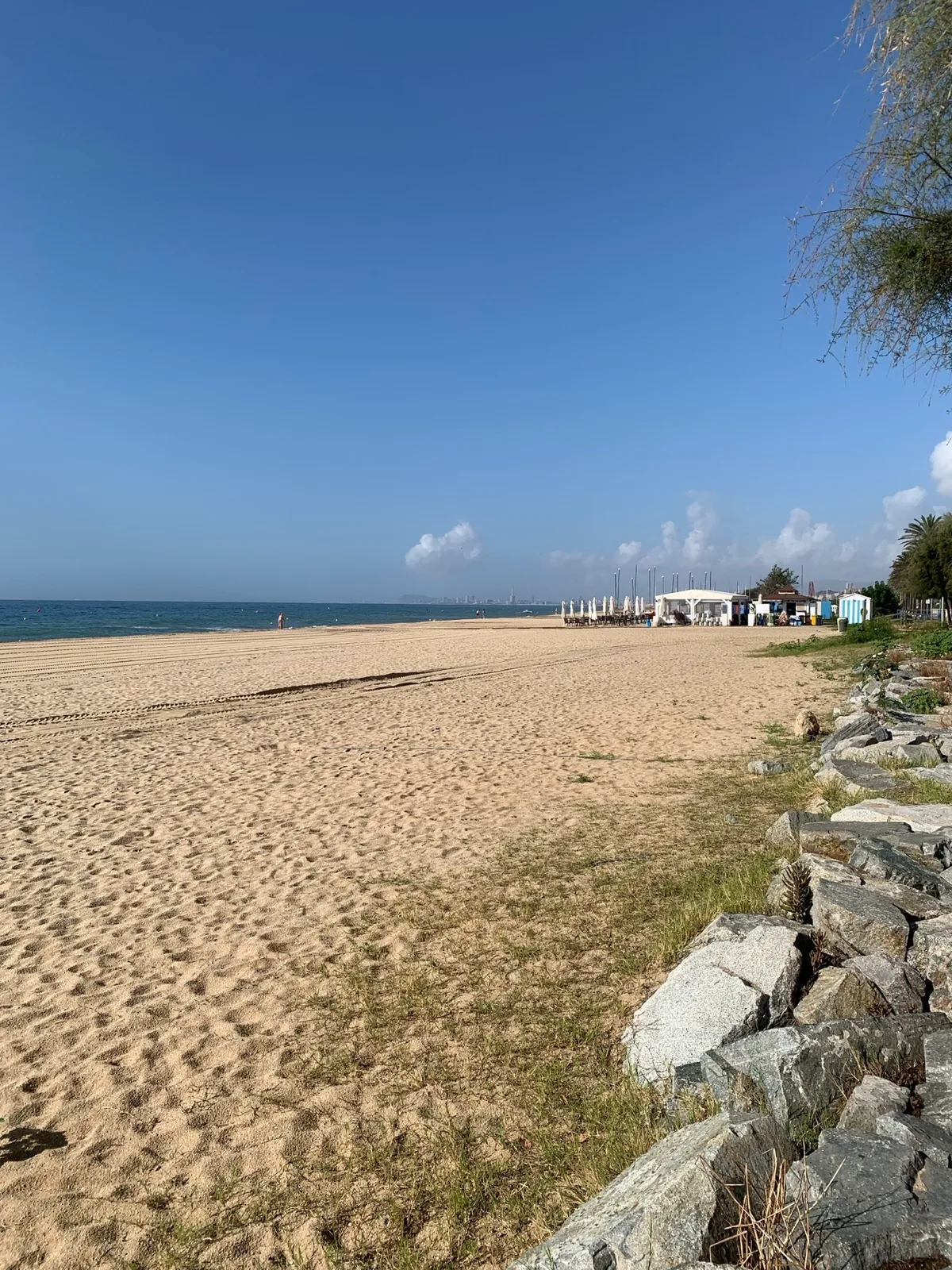 Spiaggia lunga con scogli e il mare azzurro