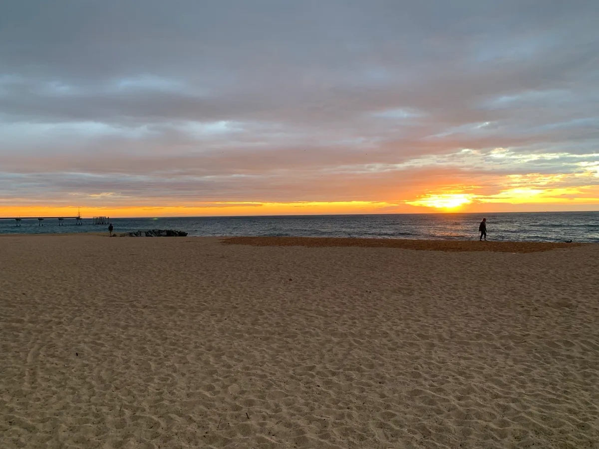 Alba arancione sul mare con la spiaggia deserta