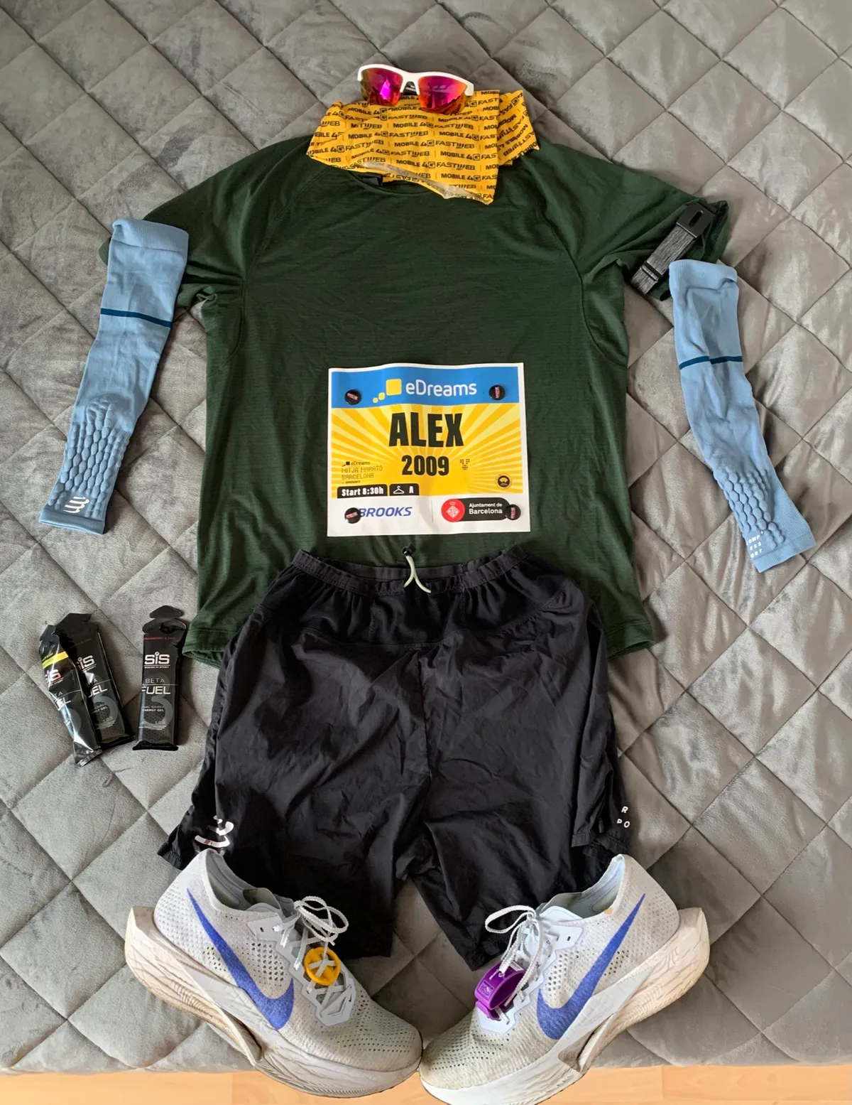 Maglia verde, pettorale, manicotti, scarpe e scaldacollo preparati prima della mezza maratona di Barcellona