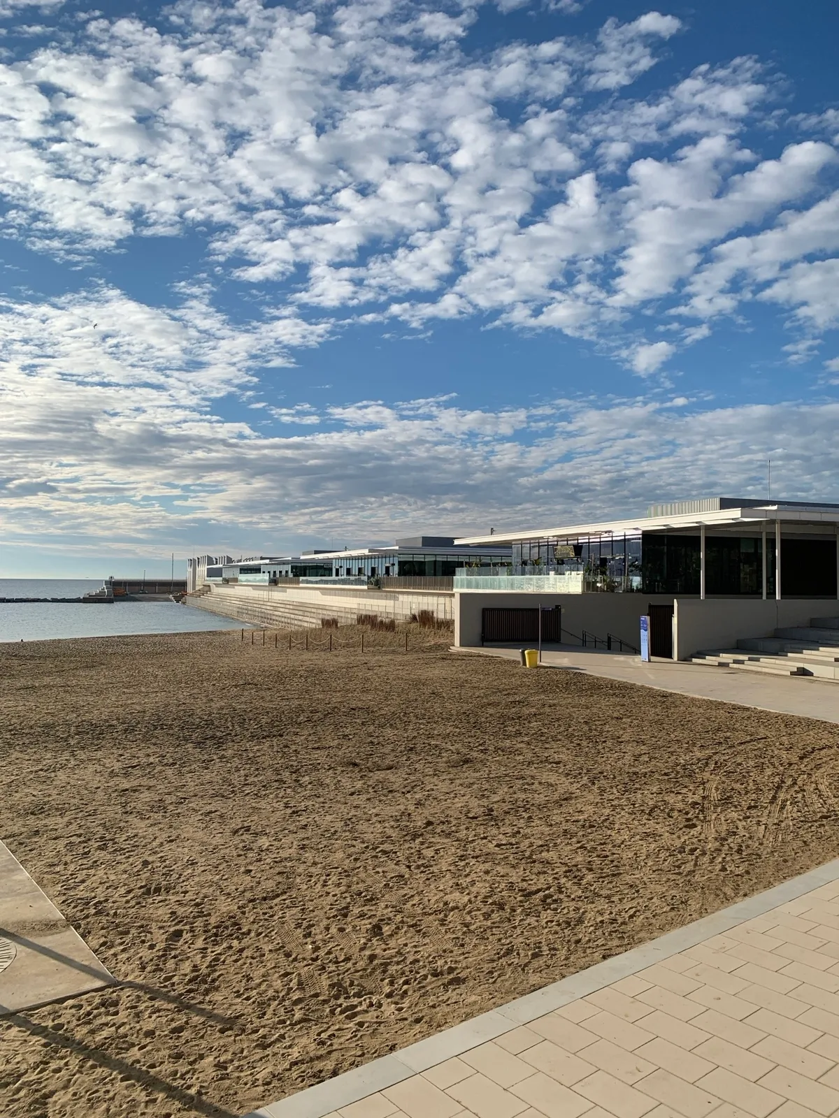 Spiaggia con un edificio sul lungomare e nuvole sparse