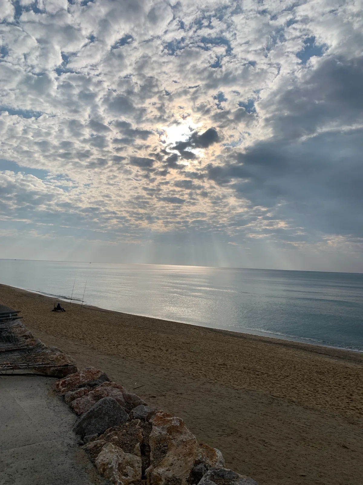 Nuvole e raggi di sole sul mare dalla spiaggia