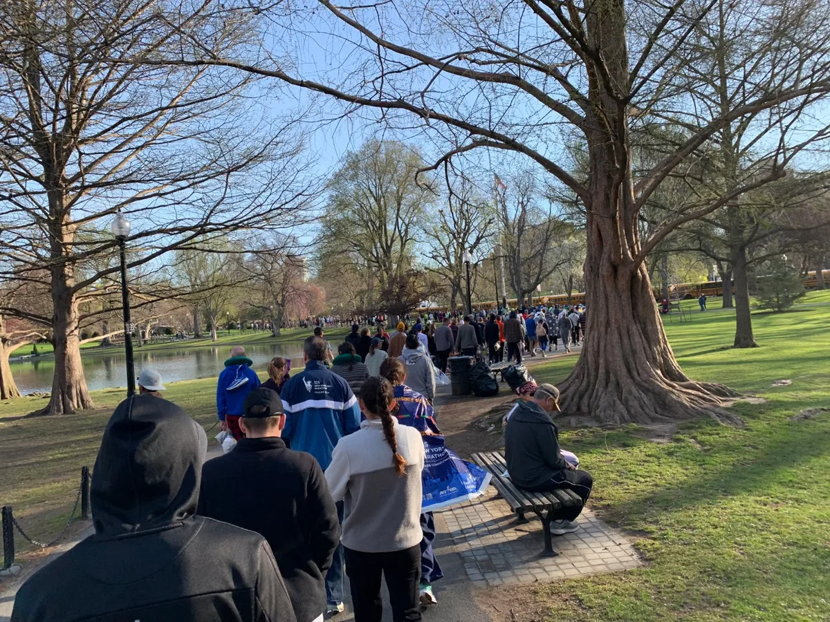 Runner in coda sotto gli alberi nel parco prima della partenza della Maratona di Boston