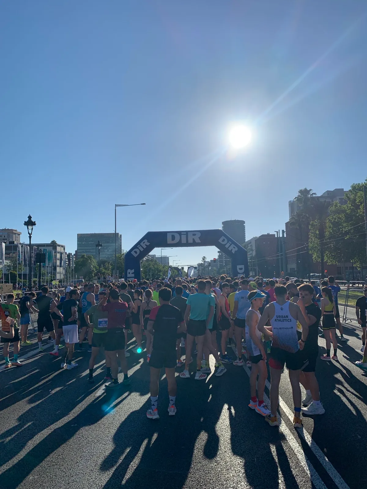 Runner alla partenza di una gara con l'arco gonfiabile e il sole controluce