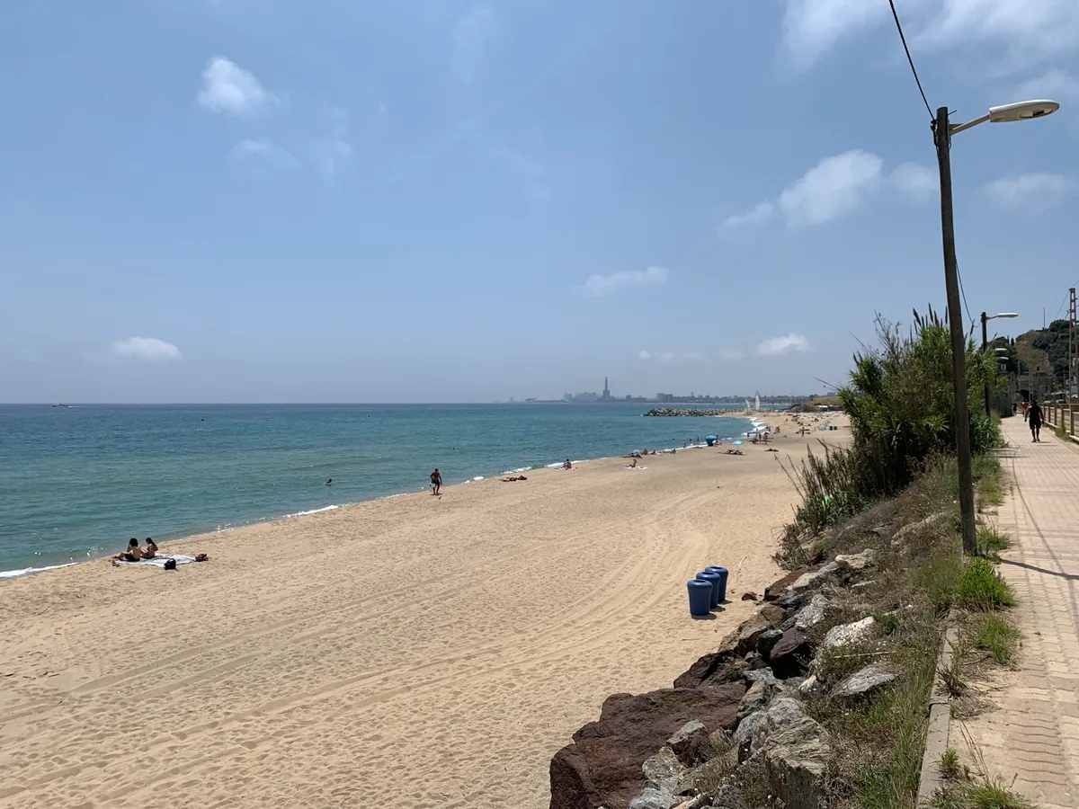 Spiaggia lunga con il mare azzurro e un lampione