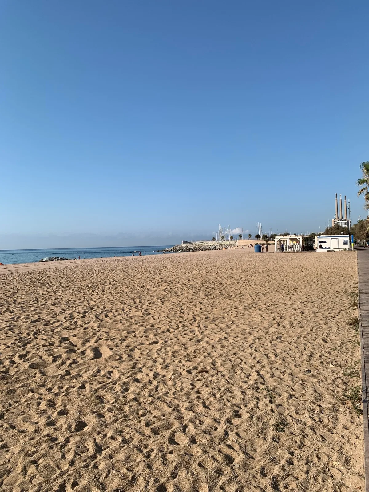 Spiaggia deserta con le ciminiere in lontananza