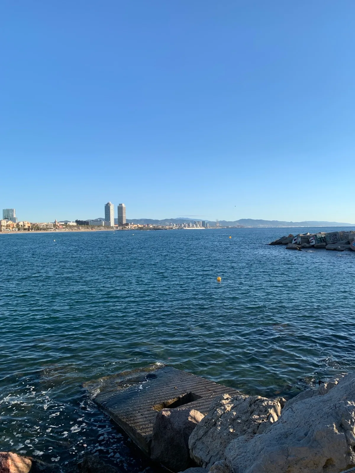 Baia di Barcellona vista dagli scogli con il mare blu