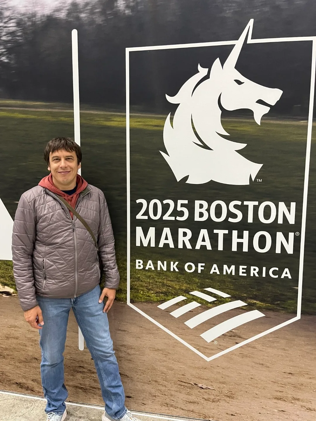 Davanti al logo della Boston Marathon 2025 con l'unicorno