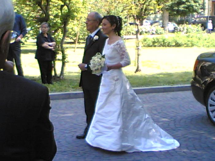 Sposa con il padre che cammina in una piazza verso la cerimonia