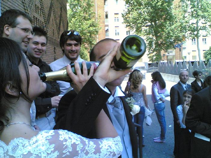Sposi e invitati che brindano con una bottiglia di spumante