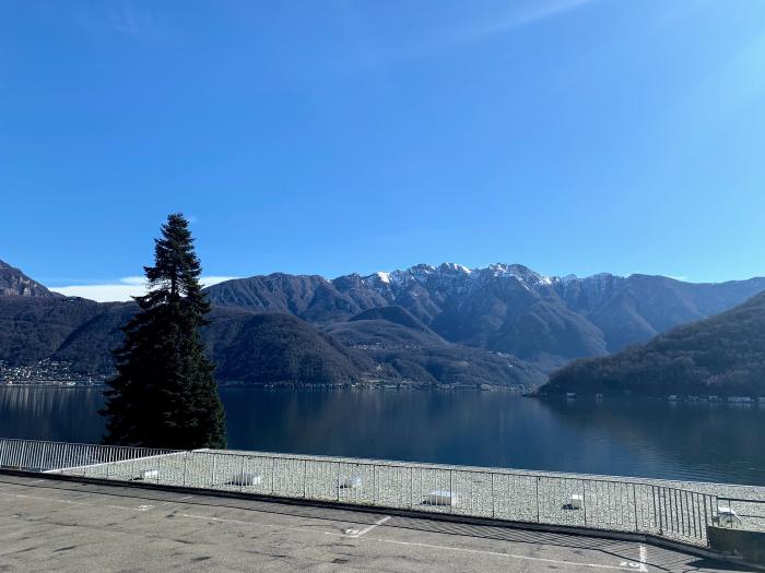 Lago e montagne viste da una terrazza sotto un cielo azzurro