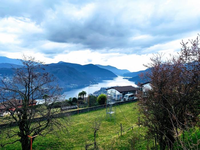 Lago visto tra gli alberi dalla collina con le nuvole