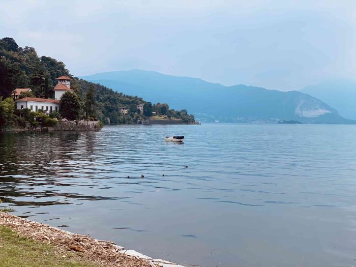 Lago con una villa sulla riva e le montagne nella foschia