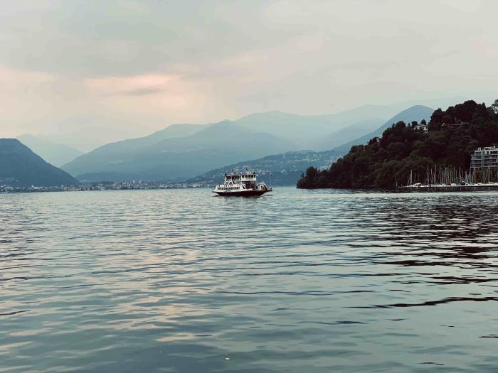 Traghetto sul lago con le montagne sullo sfondo