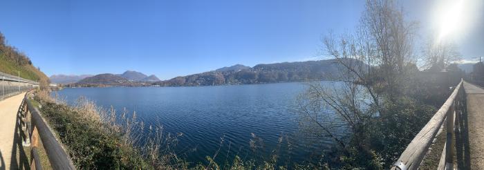 Lago con una passerella di legno e le montagne sullo sfondo