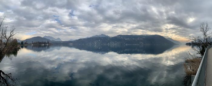 Lago calmo con il riflesso delle nuvole e le montagne