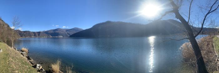 Lago blu con il sole e le montagne sullo sfondo