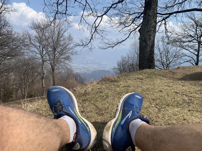 Piedi con scarpe da corsa blu che riposano su un prato con vista