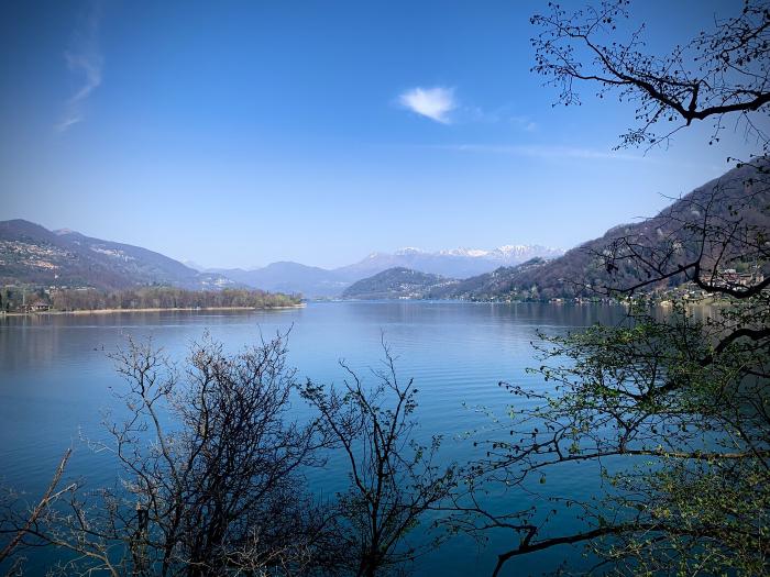 Lago blu tra le montagne visto attraverso i rami
