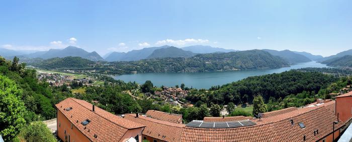 Panorama sul lago e le montagne sopra i tetti rossi del paese